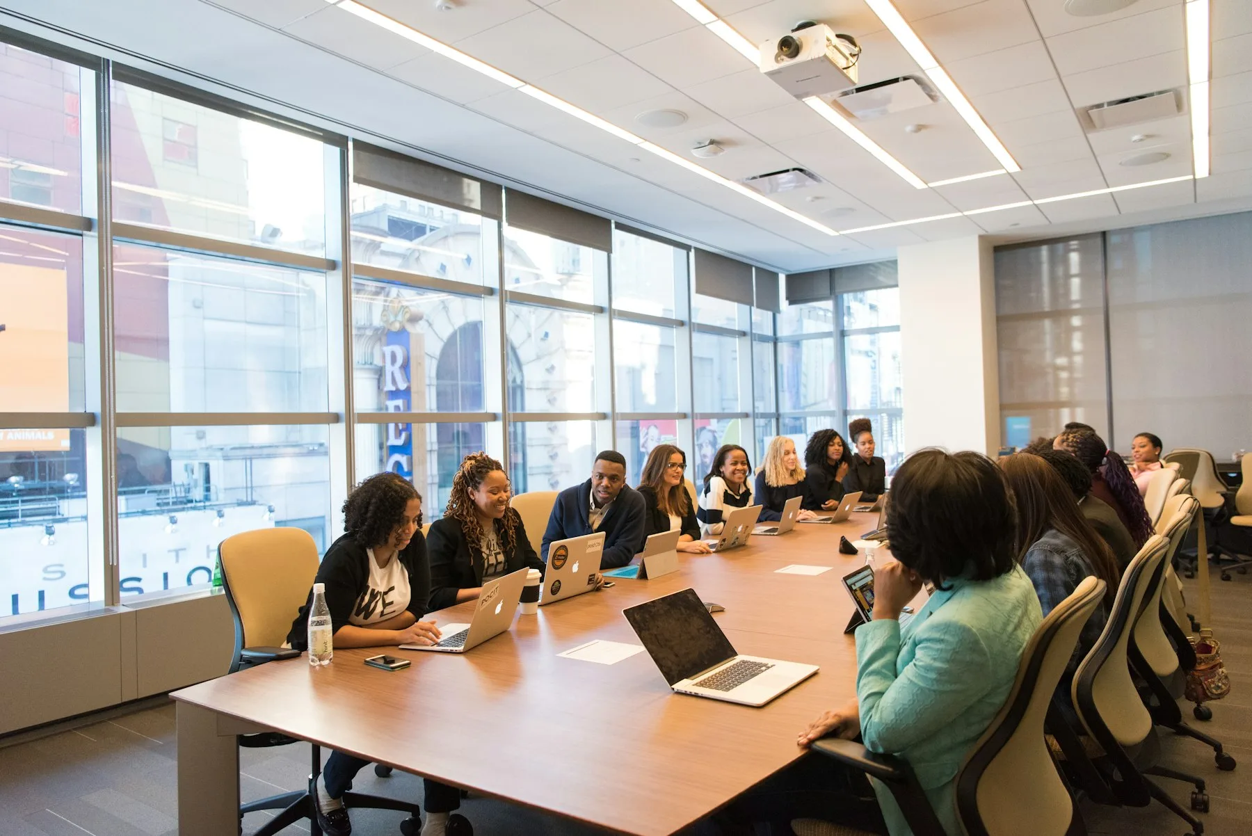 Investors and founders meeting around a boardroom table in a glass-walled downtown office